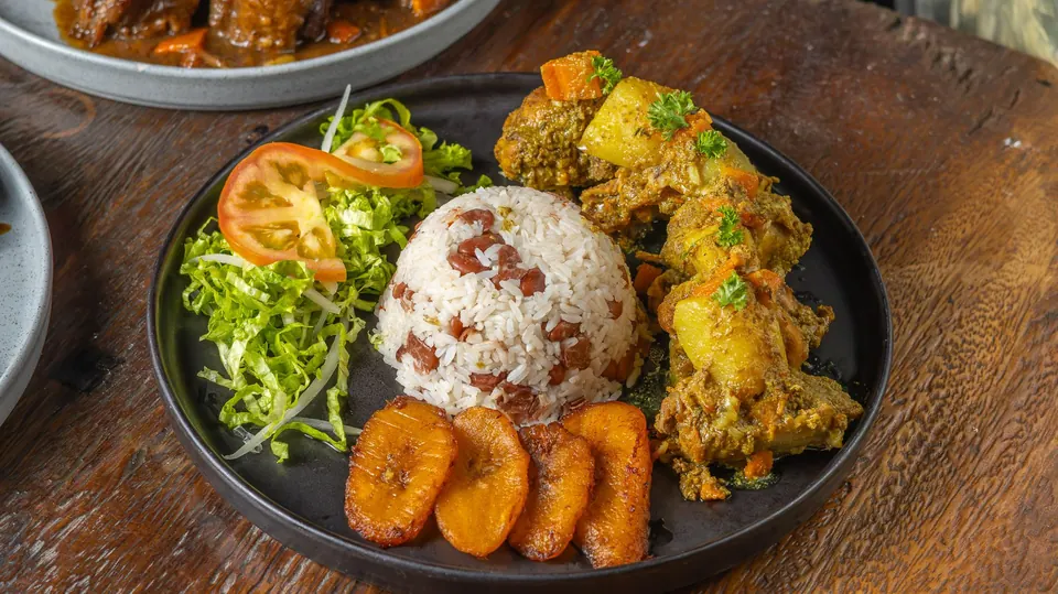 Curry Chicken with potato, rice and peas, cabbage and sweet plantain